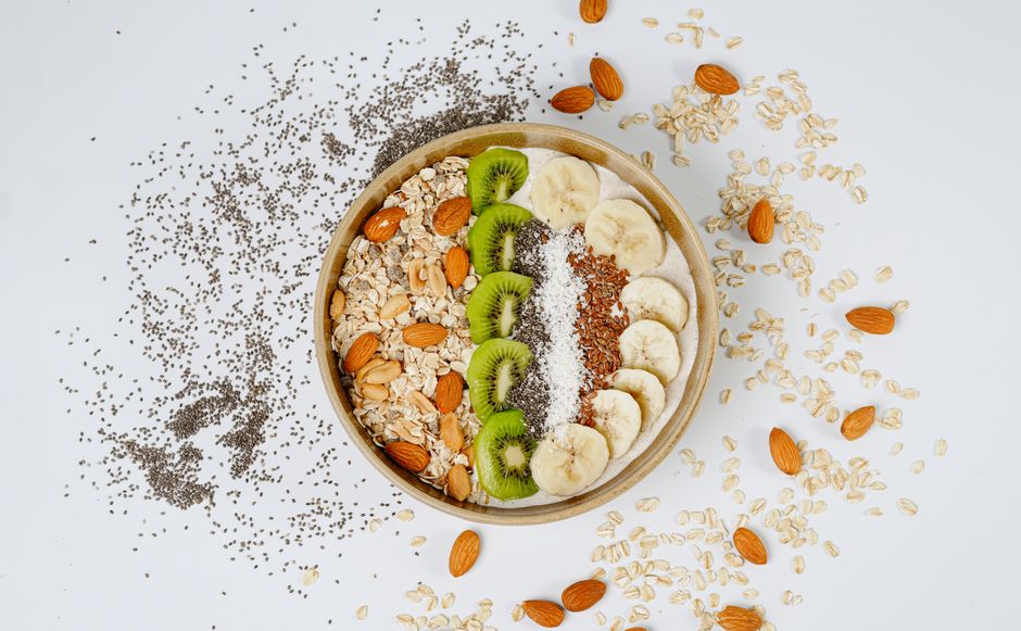 A delicious and nutritious breakfast bowl with kiwi, banana, almonds, and chia seeds.